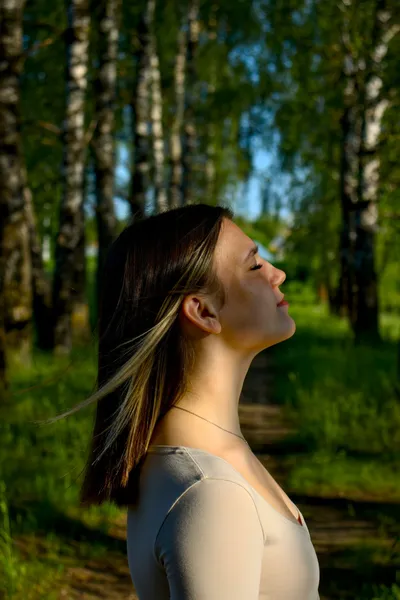 Woman practicing deep breathing in a park, a calming technique for anxiety and overactive bladder