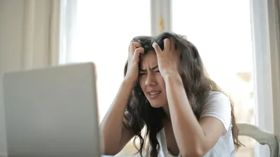 Woman looking anxious at her desk, illustrating how stress can contribute to UTI risk through cortisol and immune suppression
