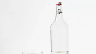 Glass of water next to a water bottle representing healthy hydration for bladder health