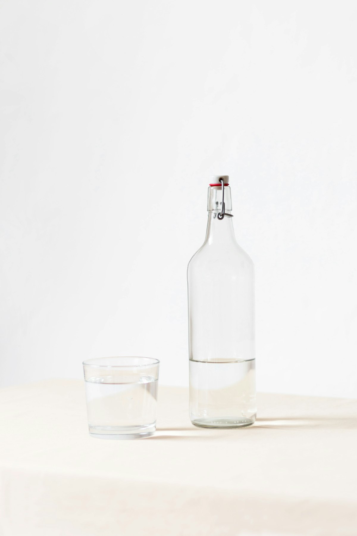 Glass of water next to a water bottle representing healthy hydration for bladder health
