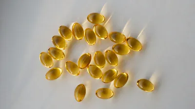 Krill oil supplement capsules alongside a glass of water for bladder health