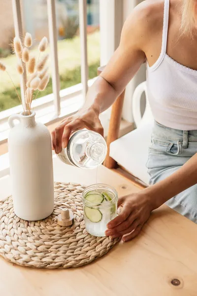 Woman drinking a glass of water, a simple habit to help prevent UTI after sex
