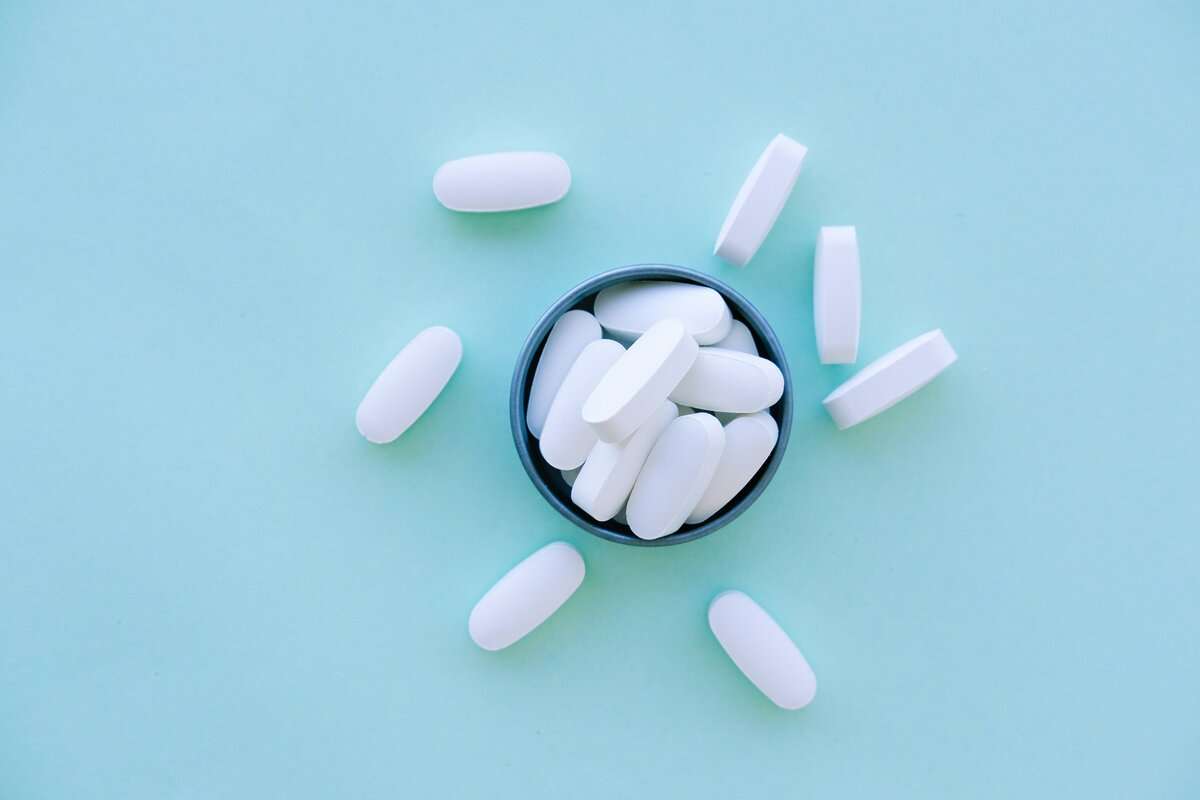 Supplement capsules in a bowl, representing quercetin for interstitial cystitis treatment