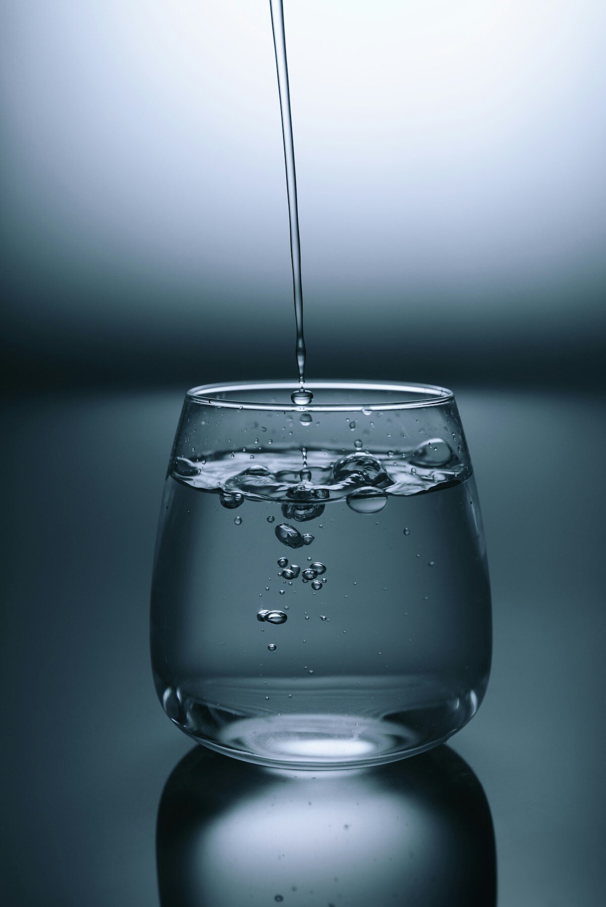 Person holding a glass of water during cancer recovery, representing hydration for radiation cystitis management