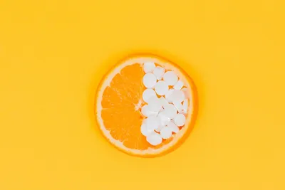 Fresh oranges and vitamin C supplements on a table for urinary tract health