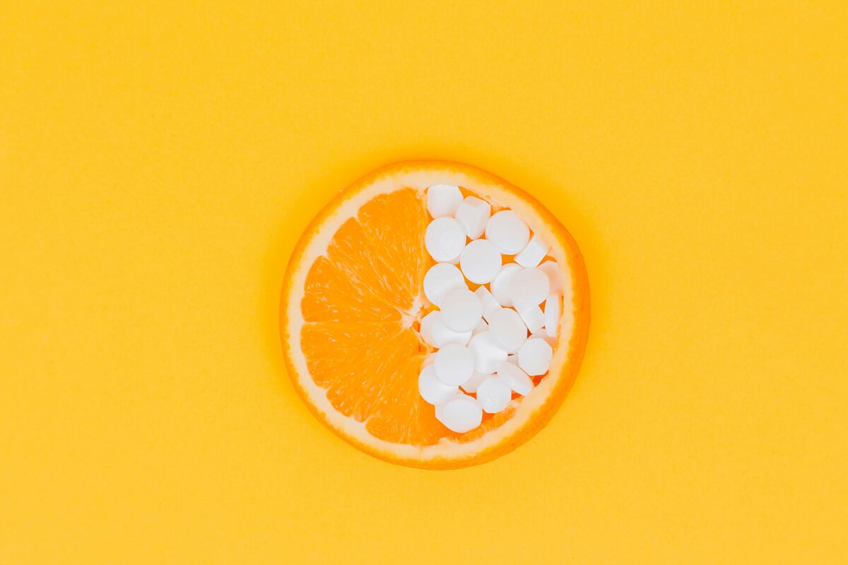Fresh oranges and vitamin C supplements on a table for urinary tract health